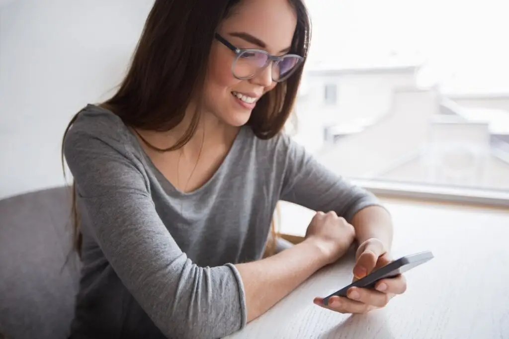 woman using MYNDIFY on her phone smiling