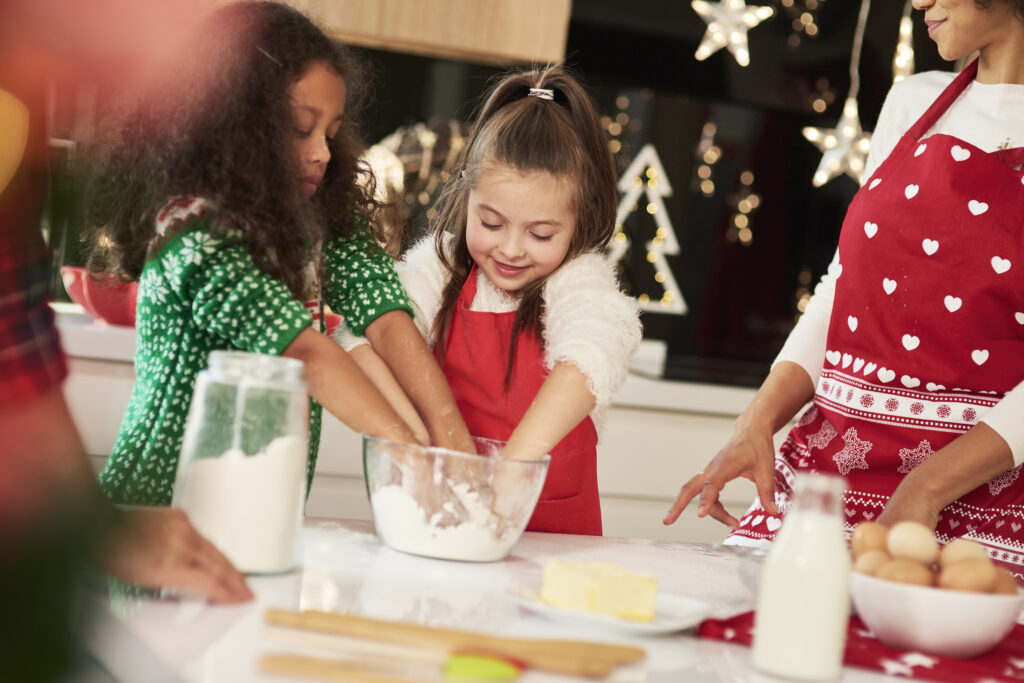 A family baking Christmas cookie together for a family gathering.