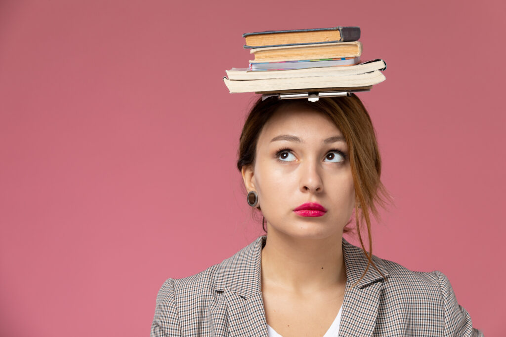 Woman holding a lot of information (shown as books) in her head which symbolize mental load
