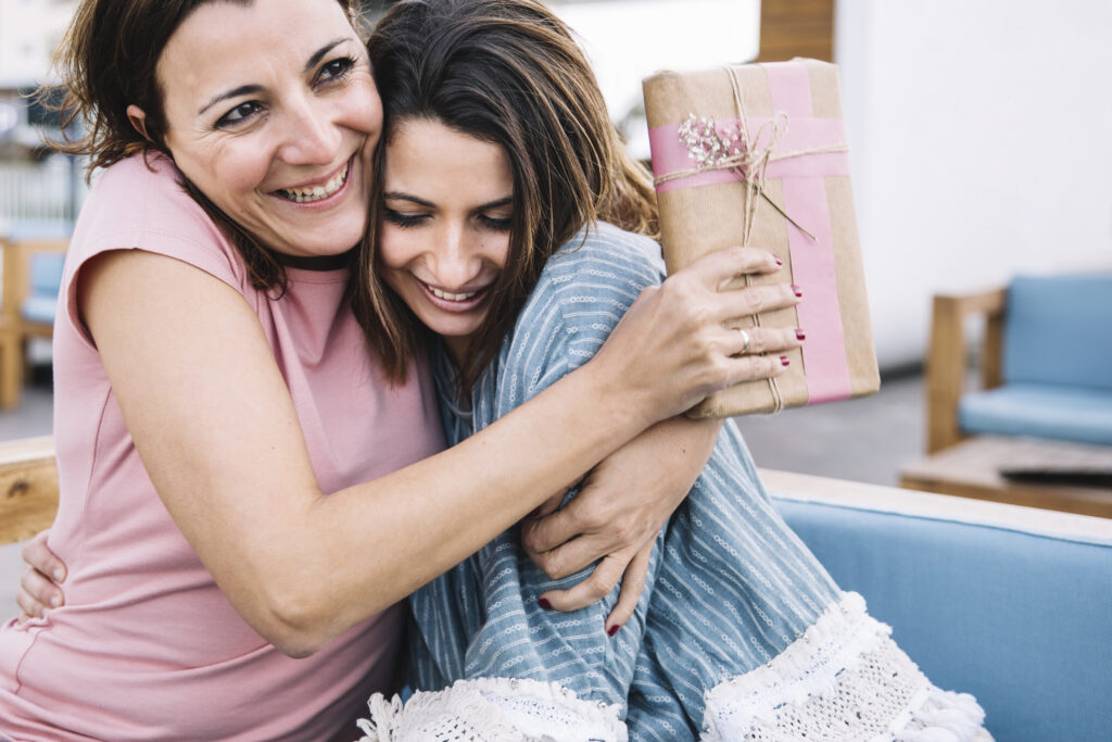 Gifting a top mother's day gift to smiling mother that she loves