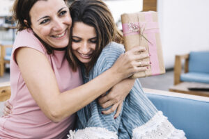 Gifting a top mother's day gift to smiling mother that she loves